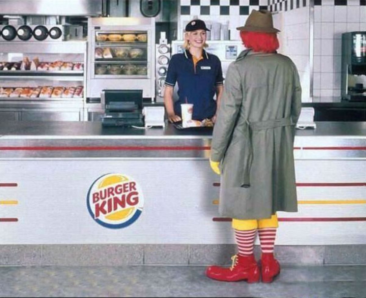 Ronald McDonald eating in a Burger King outlet